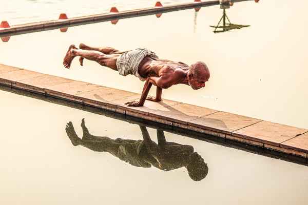 old man doing push-ups on a wood dock