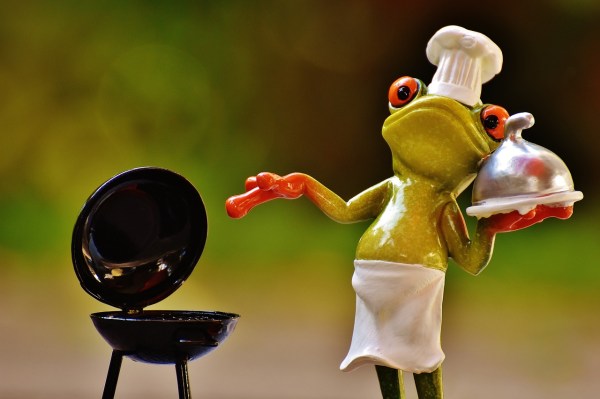 A frog wearing apron smoking meat