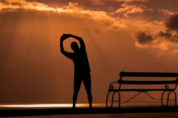 middle-aged man exercising and stretching in the early morning