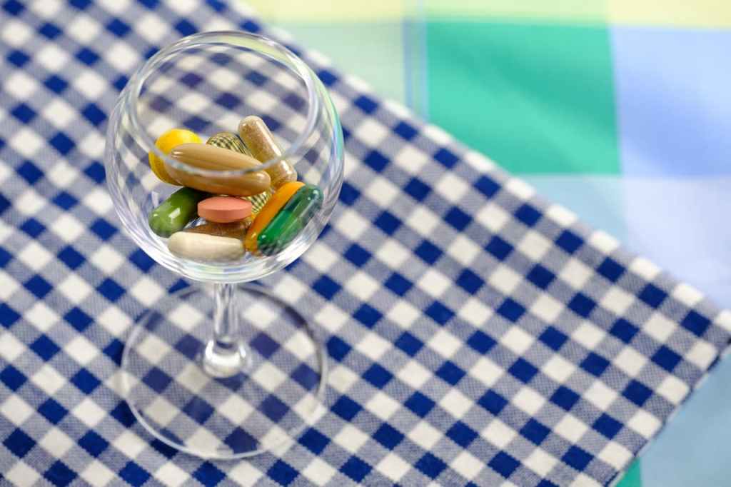 supplements in wine glass on table